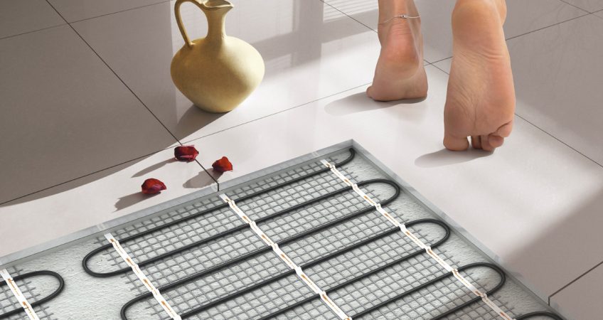 Person walking barefoot on clean white tiles view of the under tile heat installation element